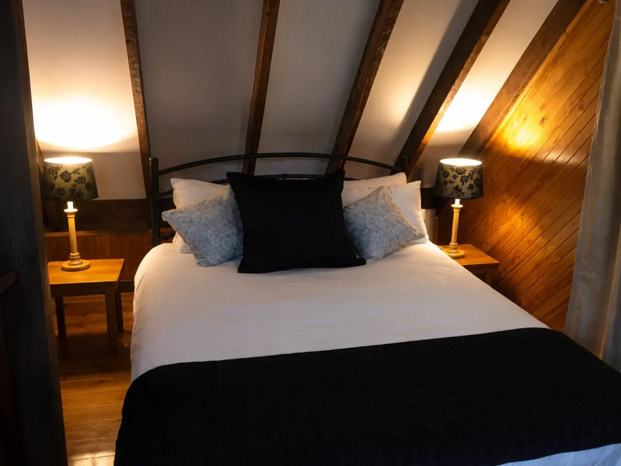 The timber interior of a chalet at Beyonderup Falls, lit by lamps