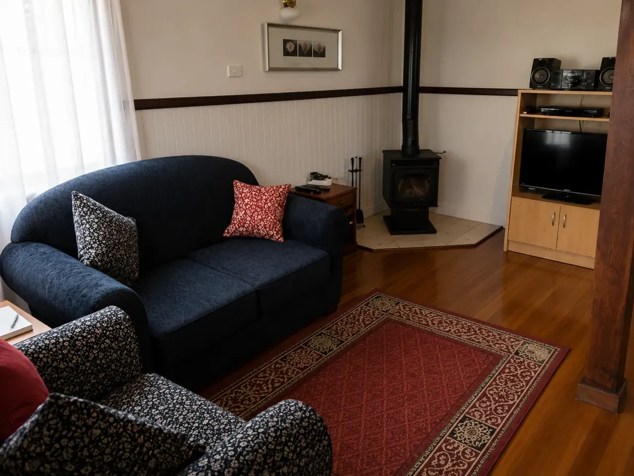 The lounge and slow combustion log fire inside a chalet at Beyonderup Falls