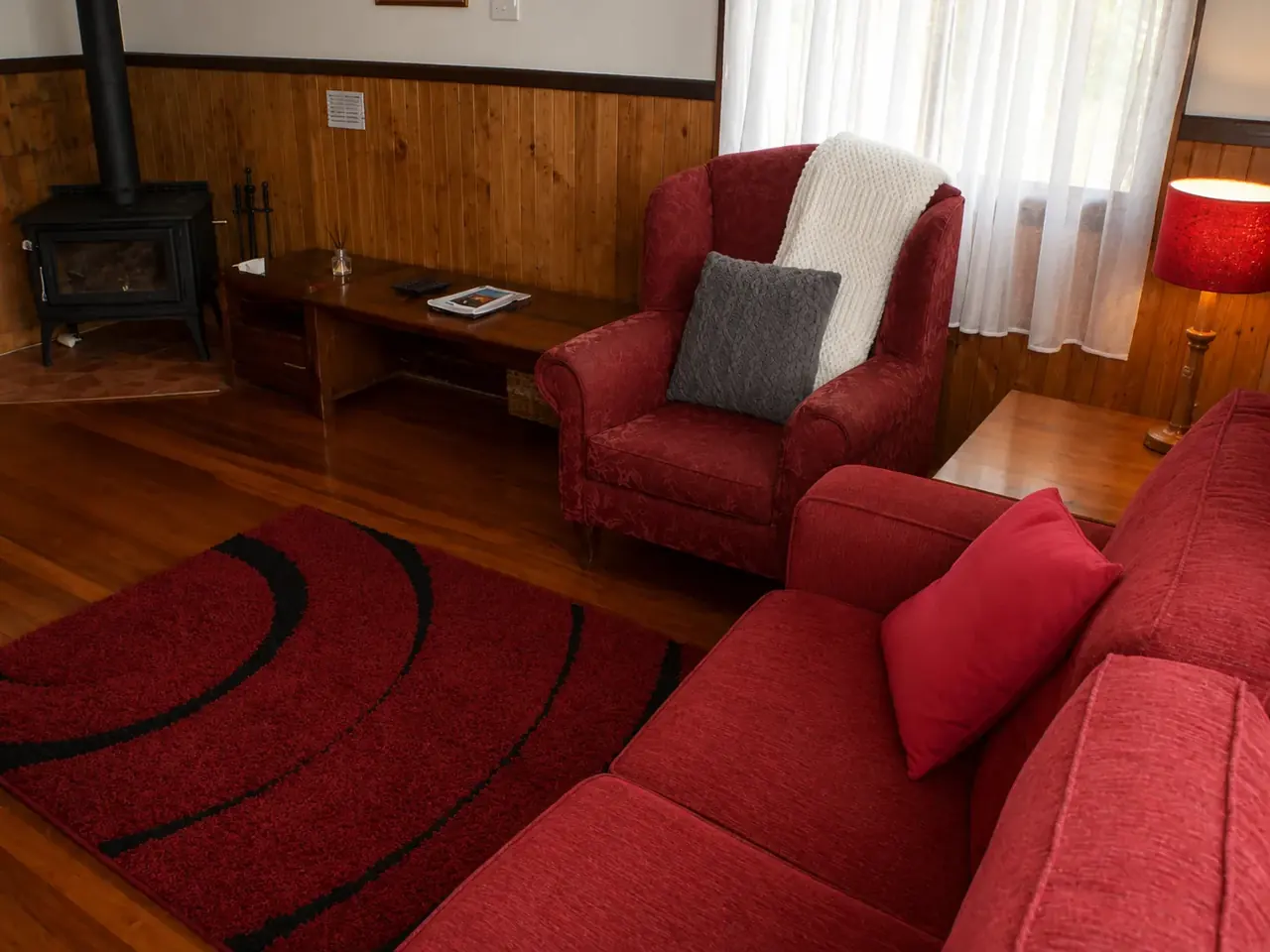 An armchair beside the window in a chalet lounge at Beyonderup Falls