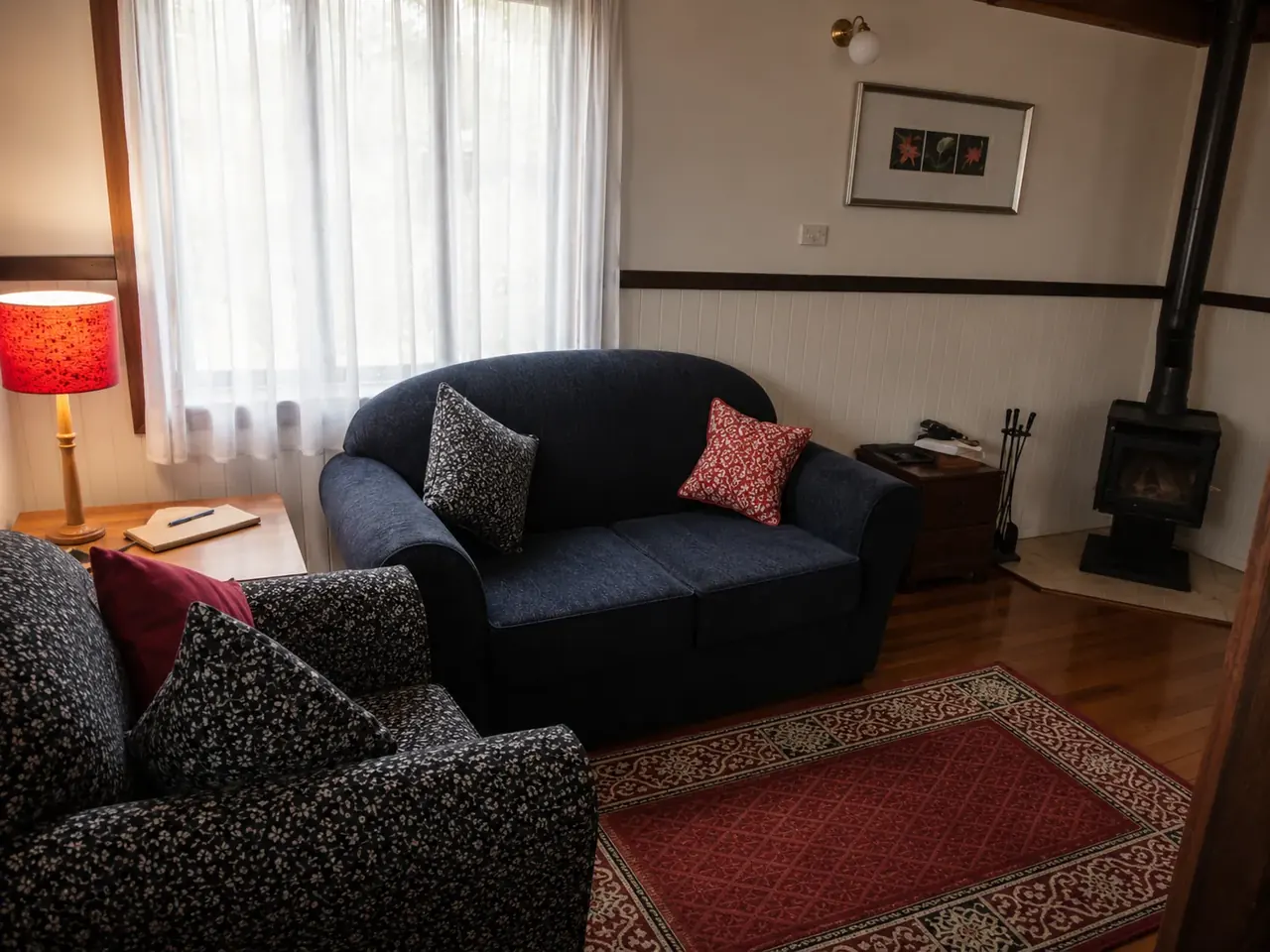 The lounge inside a chalet, with the slow combustion log fire alight