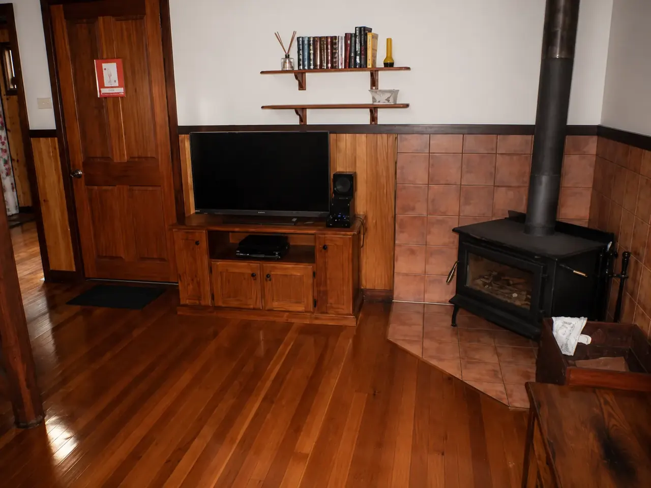 The lounge with the slow-combustion wood fire and polished floorboards