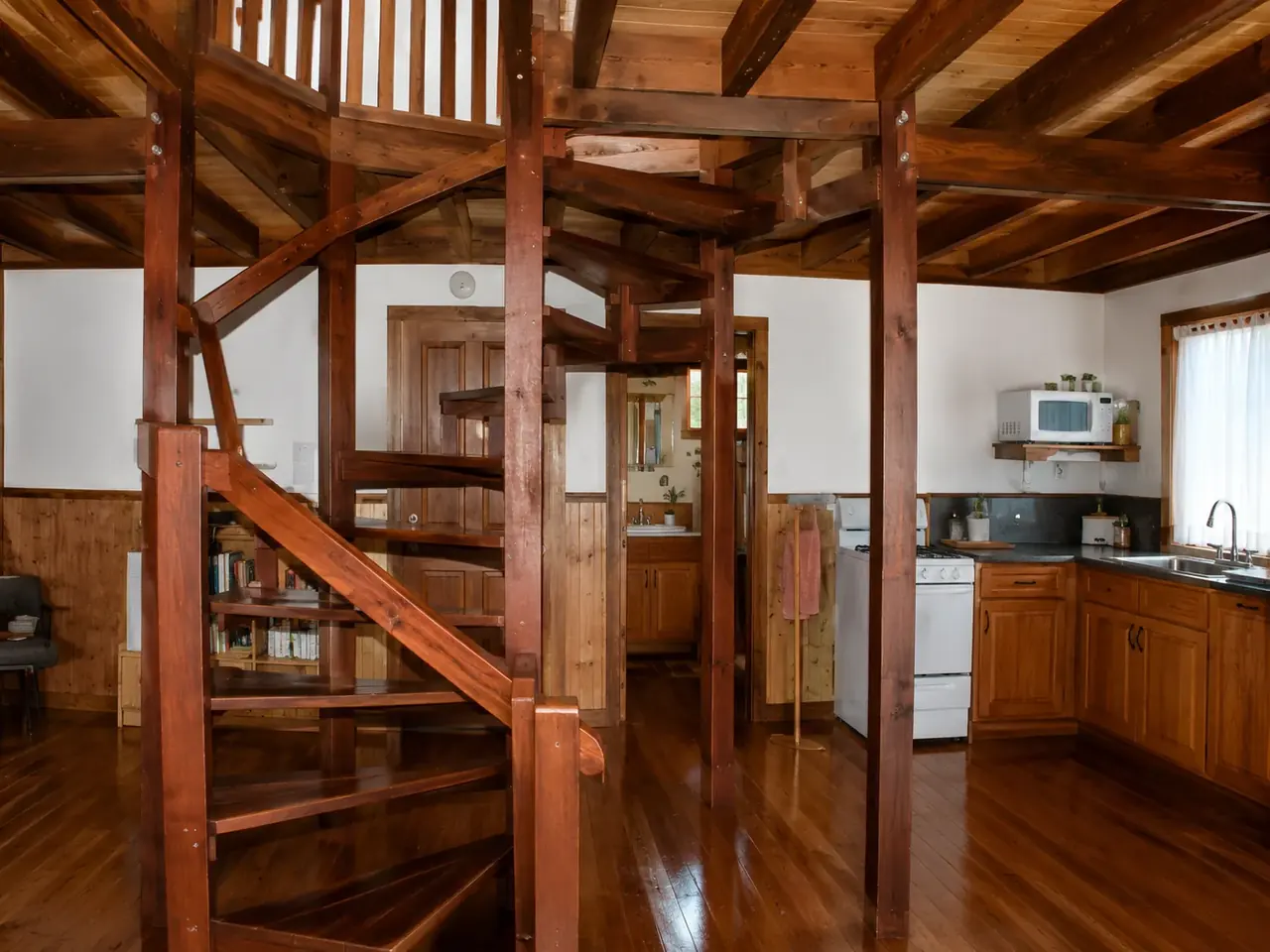 Inside a chalet at Beyonderup Falls, showing the spiral staircase and timber interior