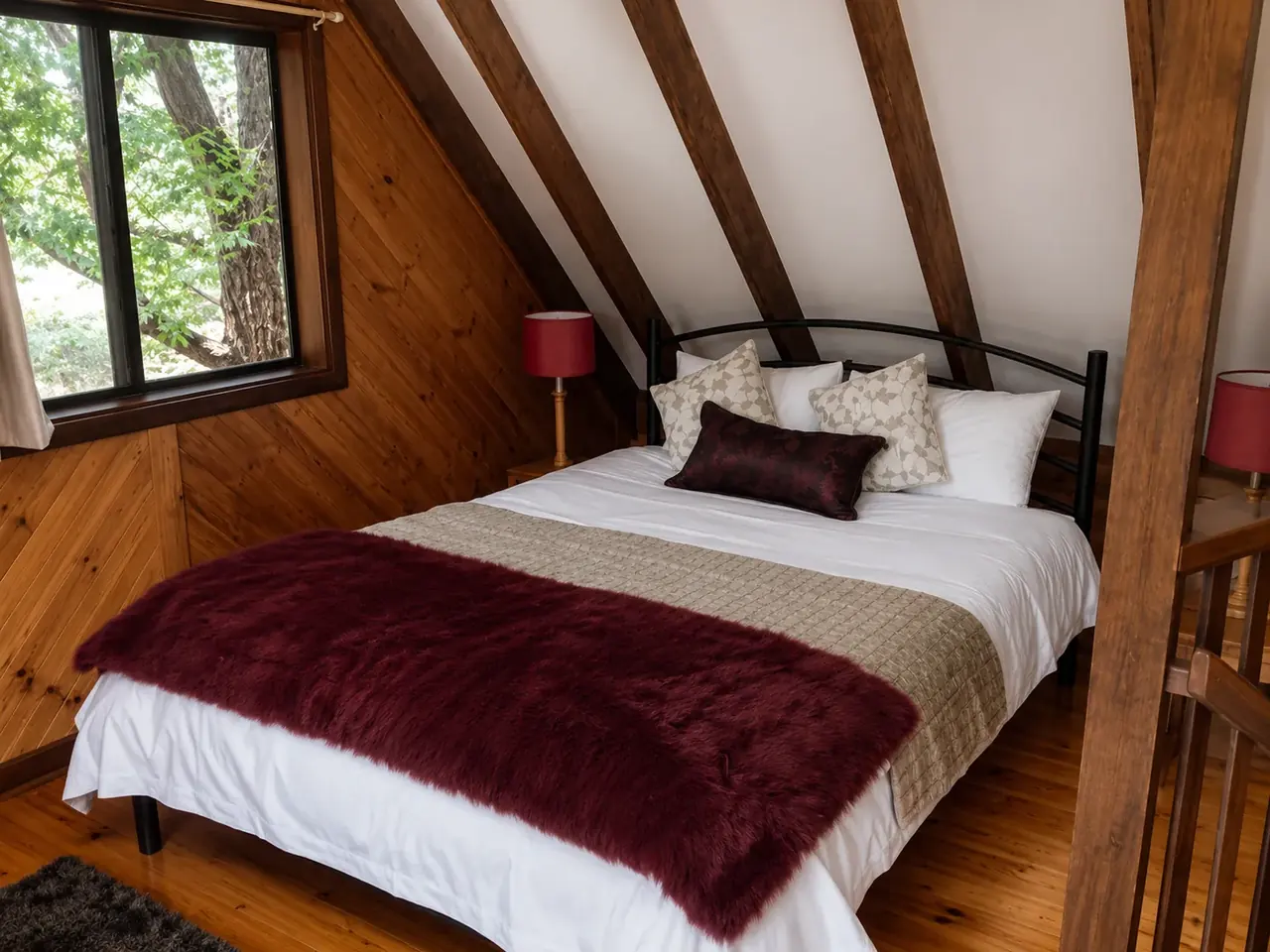 The mezzanine bed dressed with a burgundy sheepskin throw