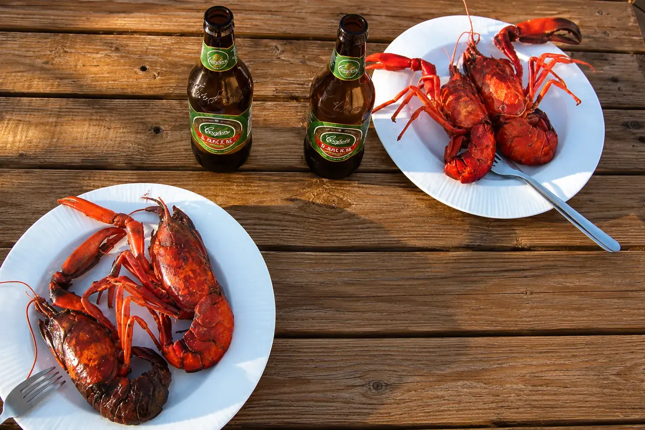 Freshly cooked marron on a plate with a drink on a timber deck