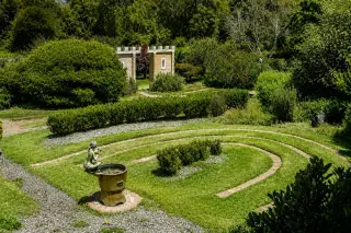 The hedge maze and brick spiral at Mythic Mazes, a small castle folly behind